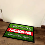 Fußmatte Rasenoptik für Fußball Fans | Hier wohnt ein Eintracht Fan - Betreten an Spieltagen auf eigene Gefahr! | Türmatte mit Spruch | 60x40cm | für innen und außen | Vorleger für Haustür / Flur