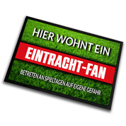 Fußmatte Rasenoptik für Fußball Fans | Hier wohnt ein Eintracht Fan - Betreten an Spieltagen auf eigene Gefahr! | Türmatte mit Spruch | 60x40cm | für innen und außen | Vorleger für Haustür / Flur