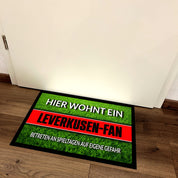 Fußmatte Rasenoptik für Fußball Fans | Hier wohnt ein Leverkusen Fan - Betreten an Spieltagen auf eigene Gefahr! | Türmatte mit Spruch | 60x40cm | für innen und außen | Vorleger für Haustür / Flur