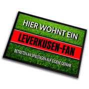 Fußmatte Rasenoptik für Fußball Fans | Hier wohnt ein Leverkusen Fan - Betreten an Spieltagen auf eigene Gefahr! | Türmatte mit Spruch | 60x40cm | für innen und außen | Vorleger für Haustür / Flur