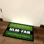 Fußmatte Rasenoptik für Fußball Fans | Hier wohnt ein Ulm Fan - Betreten an Spieltagen auf eigene Gefahr! | Türmatte mit Spruch | 60x40cm | für innen und außen | Vorleger für Haustür / Flur