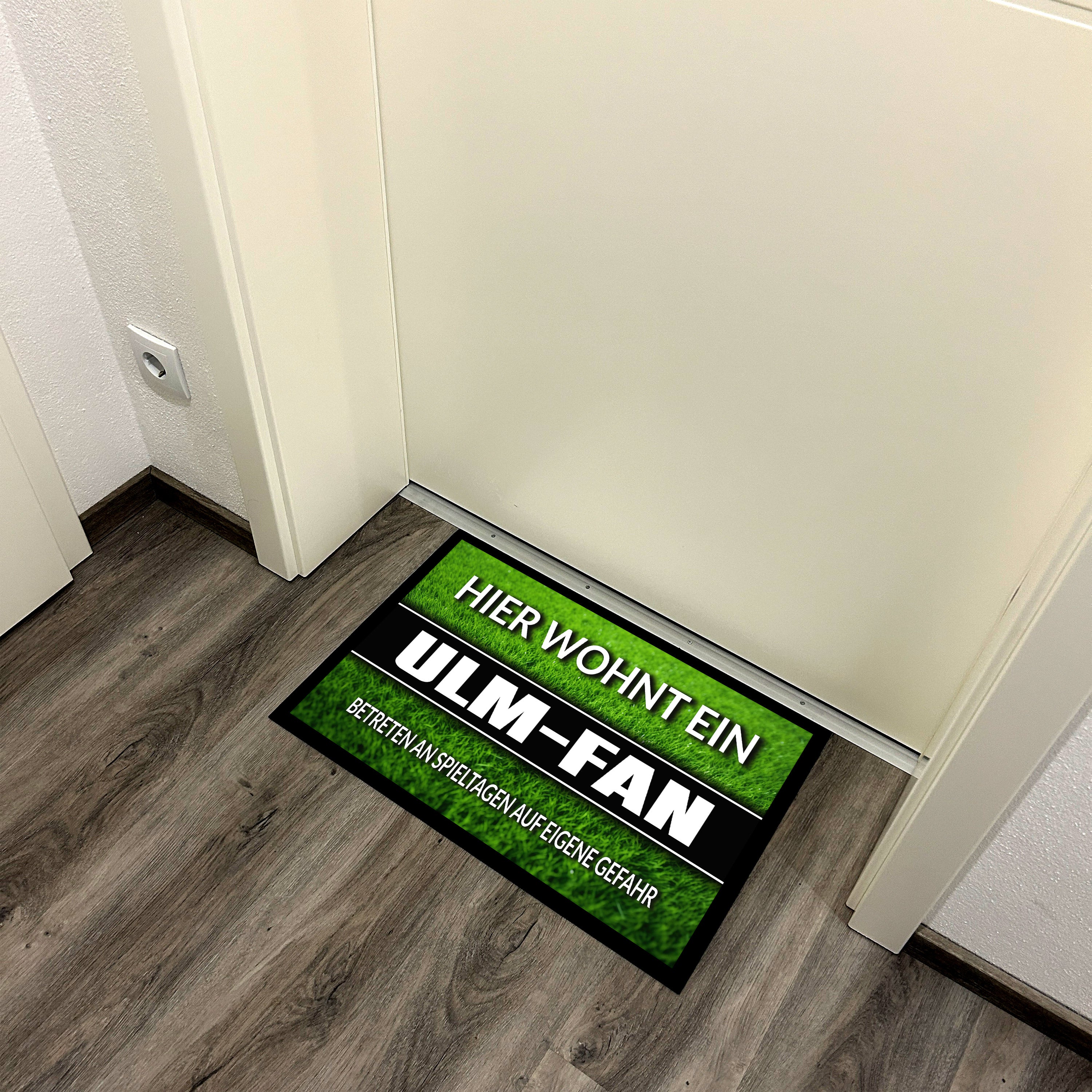 Fußmatte Rasenoptik für Fußball Fans | Hier wohnt ein Ulm Fan - Betreten an Spieltagen auf eigene Gefahr! | Türmatte mit Spruch | 60x40cm | für innen und außen | Vorleger für Haustür / Flur