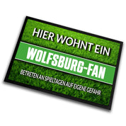 Fußmatte Rasenoptik für Fußball Fans | Hier wohnt ein Wolfsburg Fan - Betreten an Spieltagen auf eigene Gefahr! | Türmatte mit Spruch | 60x40cm | für innen und außen | Vorleger für Haustür / Flur