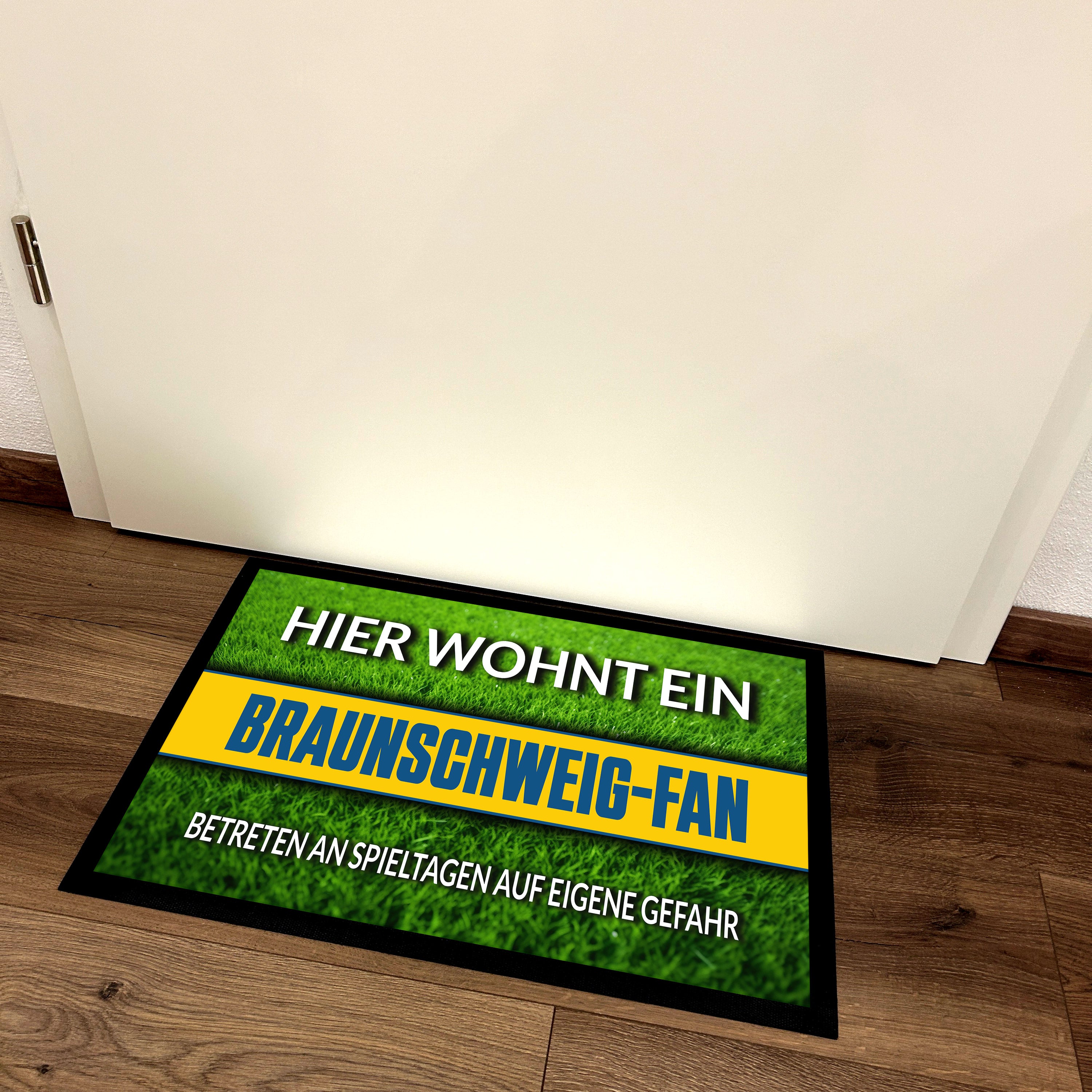Fußmatte Rasenoptik für Fußball Fans | Hier wohnt ein Braunschweig Fan - Betreten an Spieltagen auf eigene Gefahr! | Türmatte mit Spruch | 60x40cm | für innen und außen | Vorleger für Haustür / Flur