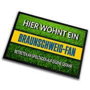 Fußmatte Rasenoptik für Fußball Fans | Hier wohnt ein Braunschweig Fan - Betreten an Spieltagen auf eigene Gefahr! | Türmatte mit Spruch | 60x40cm | für innen und außen | Vorleger für Haustür / Flur